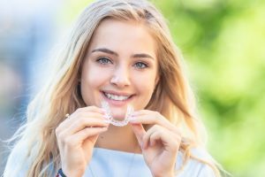 Invisalign,Orthodontics,Concept,-,Young,Attractive,Woman,Holding,-,Using
