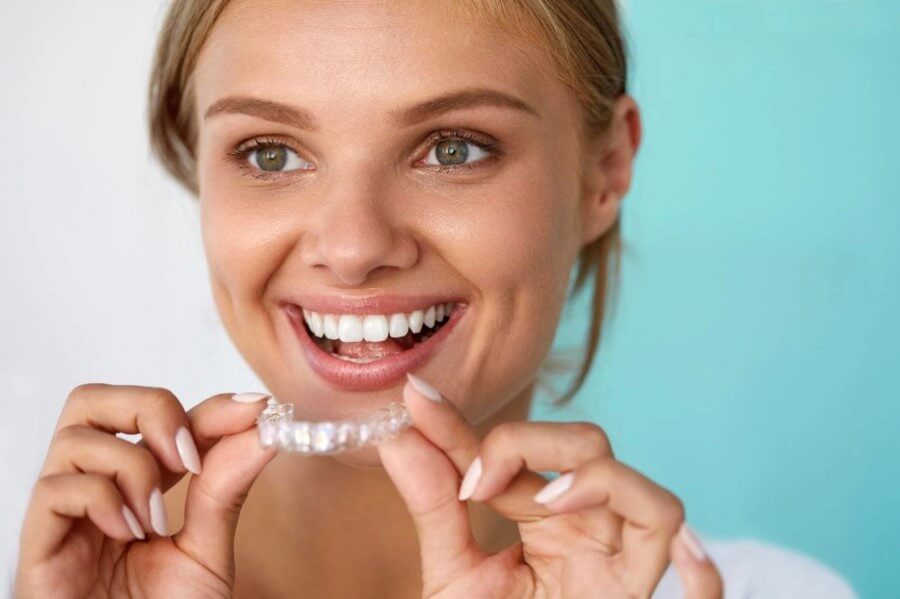 Young Lady Placing Invisalign in Kingston upon Thames